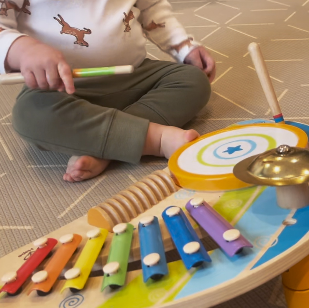 An infant playing a xylophone