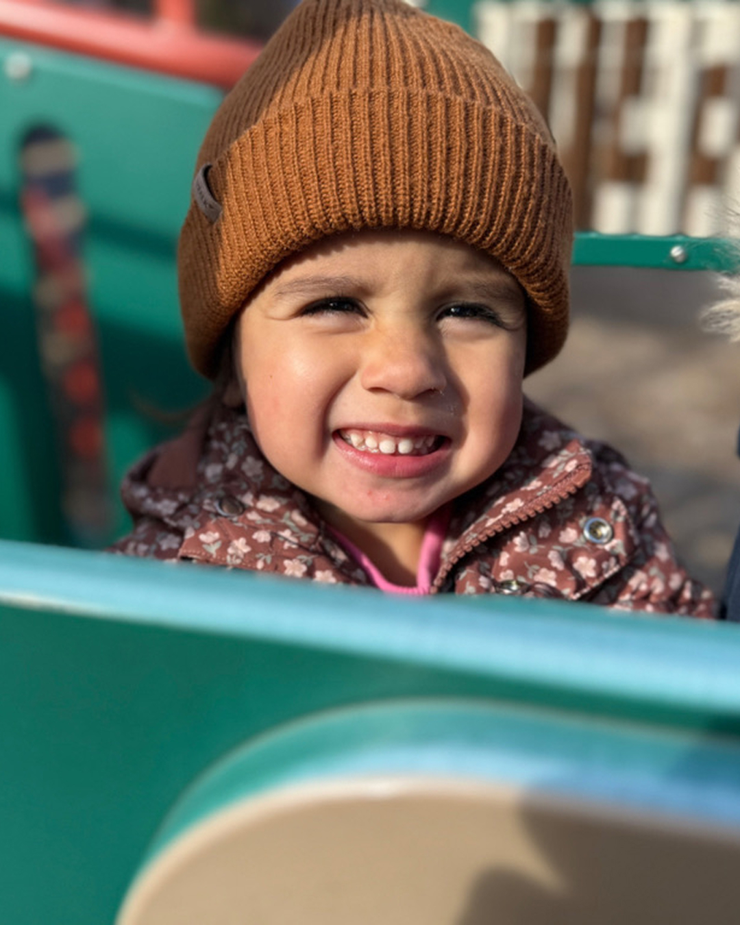 A child smiling at an outdoor park