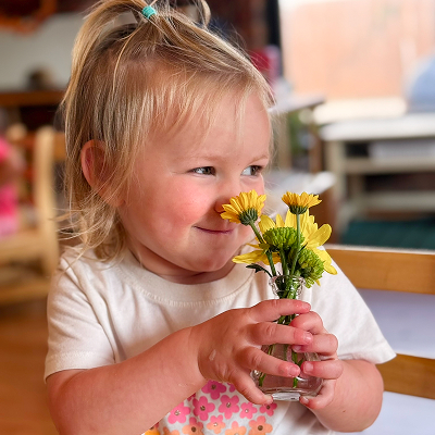A toddler holding a bunch of yellow flowers